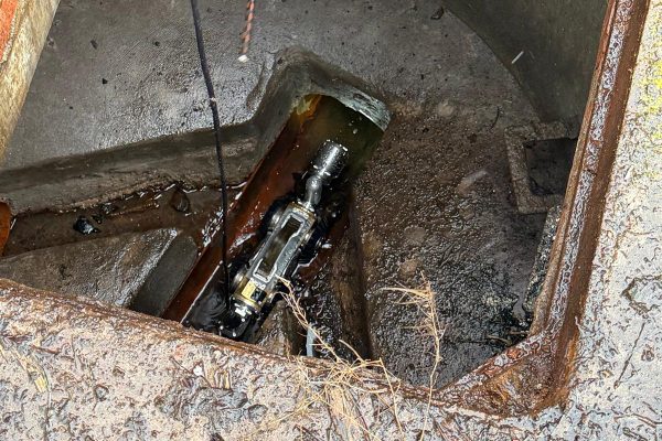 Crawler CCTV camera inspecting underground drainage from a manhole